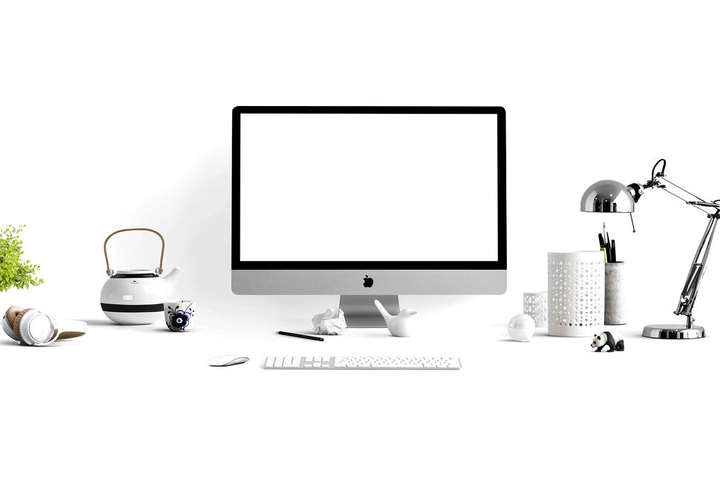 Modern well-organized office desk with computer, plants, and stationery