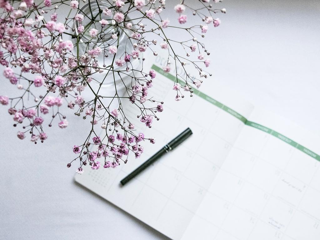 Woman writing notes in a planner at desk