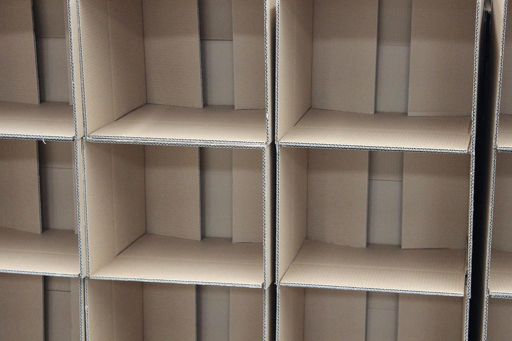 Hands arranging colorful storage boxes on shelf